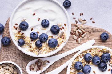 Close up of a bowl with natural yogurt and some fresh blueberries