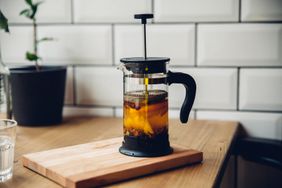 A cup of coffee being made in a French press