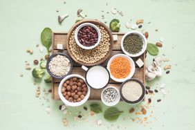Plant Protein Sources: Vegetable albumen sources. Plant protein (beans, nuts, vegetables, mushrooms, seeds) on green background.