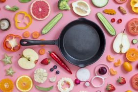 biggest-cooking-mistakes: cast iron pan surrounded by a variety of ingredients