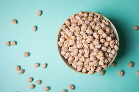 Overhead view of a bowl of chickpeas on a teal background