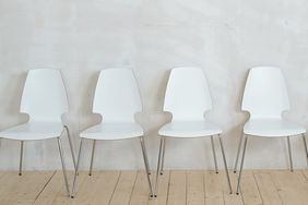 Row of white chairs near wall