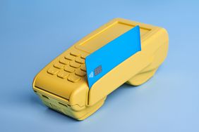 Yellow Credit Card POS Terminal On Blue Background