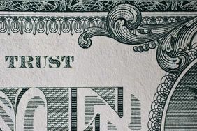 close up of the word 'trust' on a one dollar bill