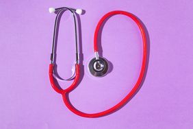 Red and silver stethoscope on a purple background.