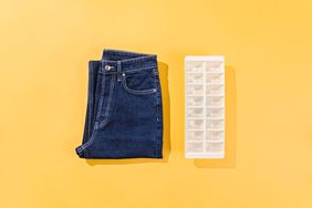 A pair of designer jeans folded into a square with a tray of ice cubes