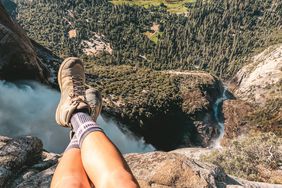 how-to-choose-hiking-boots: woman on a cliff wearing hiking boots