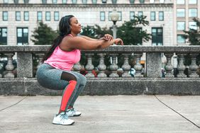 woman outside doing a squat in workout clothes