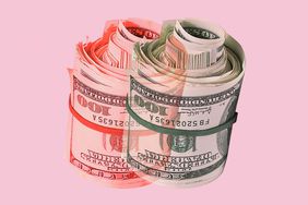 roll of 100 dollar bills with a red shadow on a pink background