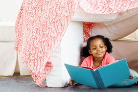 How to make a blanket fort - girl reading in blanket fort