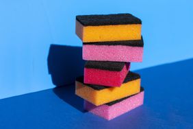 Stack of colorful cleaning sponge on blue background