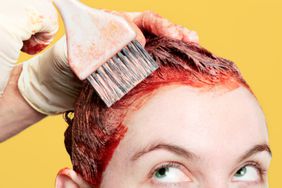 Person with red hair dye and brush 