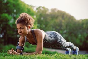 Plank Exercise Health Benefits: young woman doing plank exercise outside on the grass