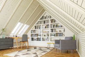 Attic room with pitched ceiling and wall of books and home office setup 