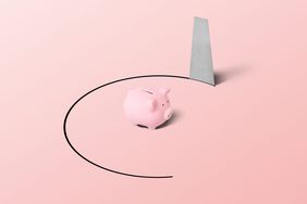 Small pink piggy bank on a pink background, with the floor being cut out by a saw
