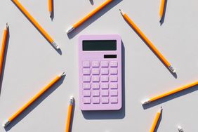Calculator and non-colored pencils on a gray background. Universal gray background. Calculator.