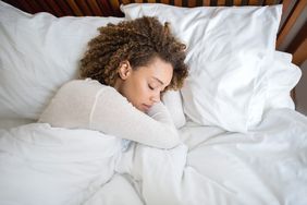 How to Sleep Better: Woman sleeping on white sheets