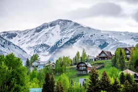 summer-vacation-ideas: cabins near a snowy mountain
