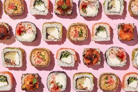 overhead of multiple pieces of sushi rolls on a pink background