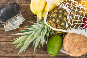 save money on food: groceries in a bag next to wallet with cash
